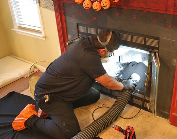 Technician sweeping a residential chimney
